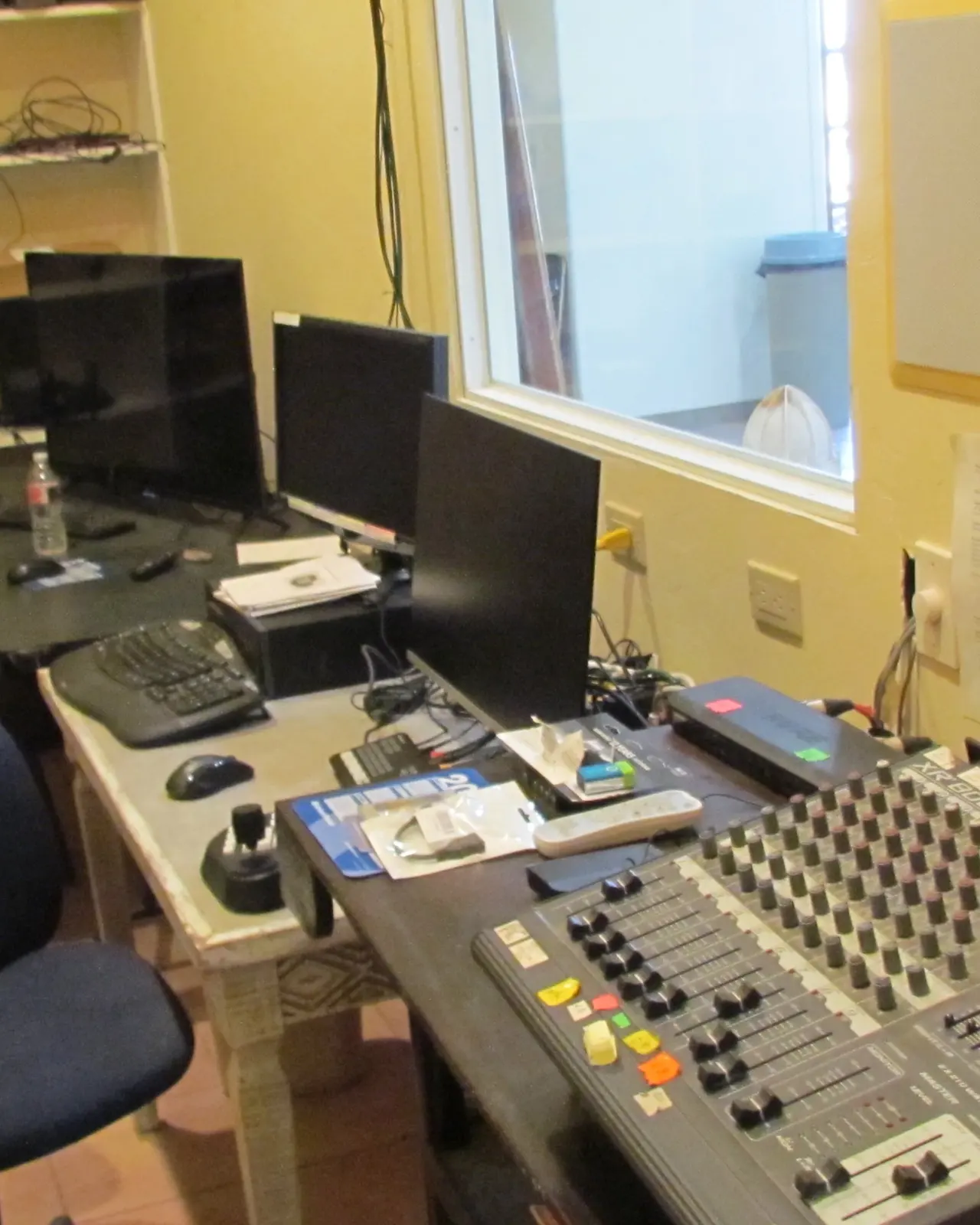 Sound booth with mixing board and monitors overlooking the hall
