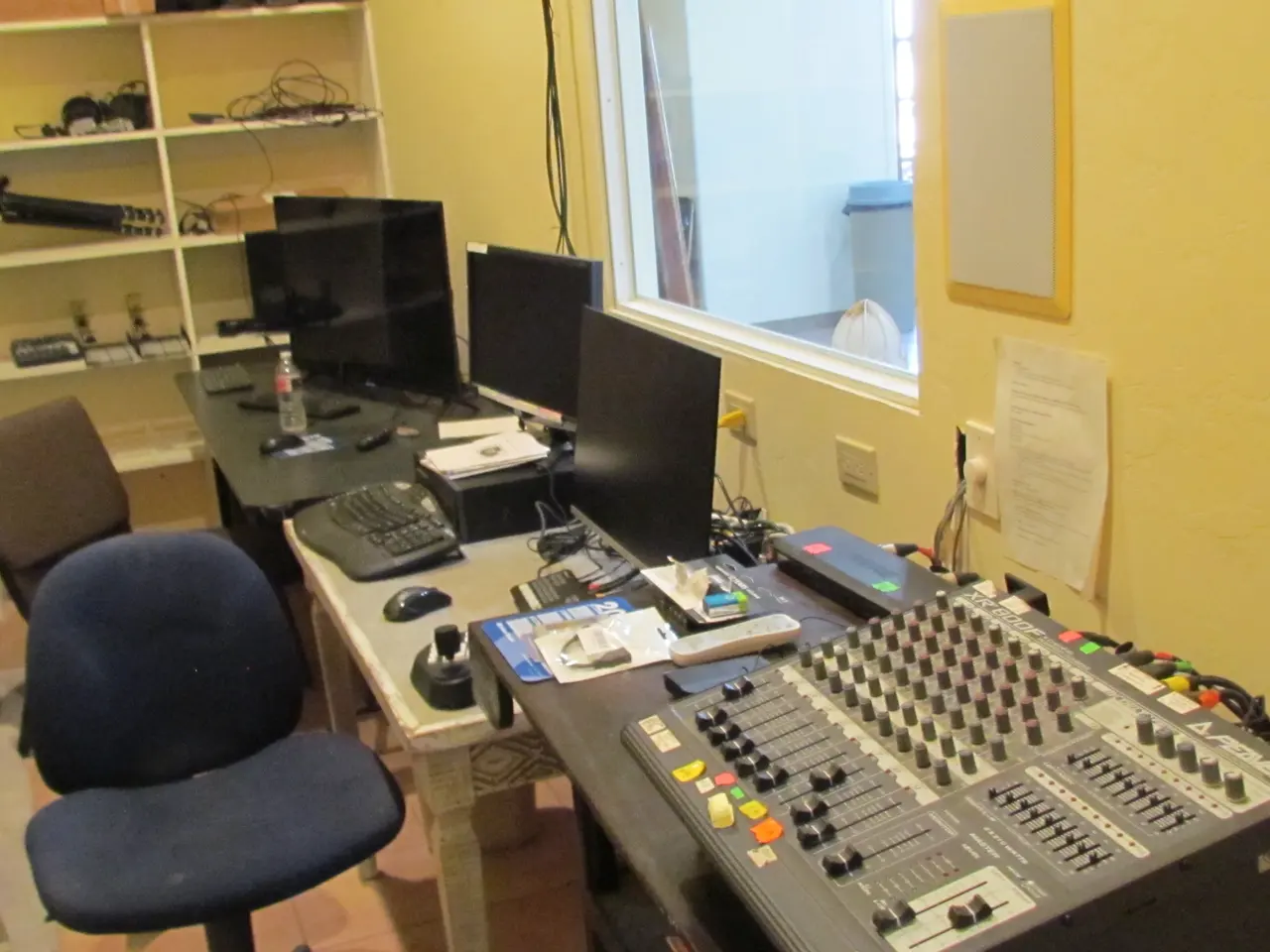 Sound booth with mixing board and monitors overlooking the hall