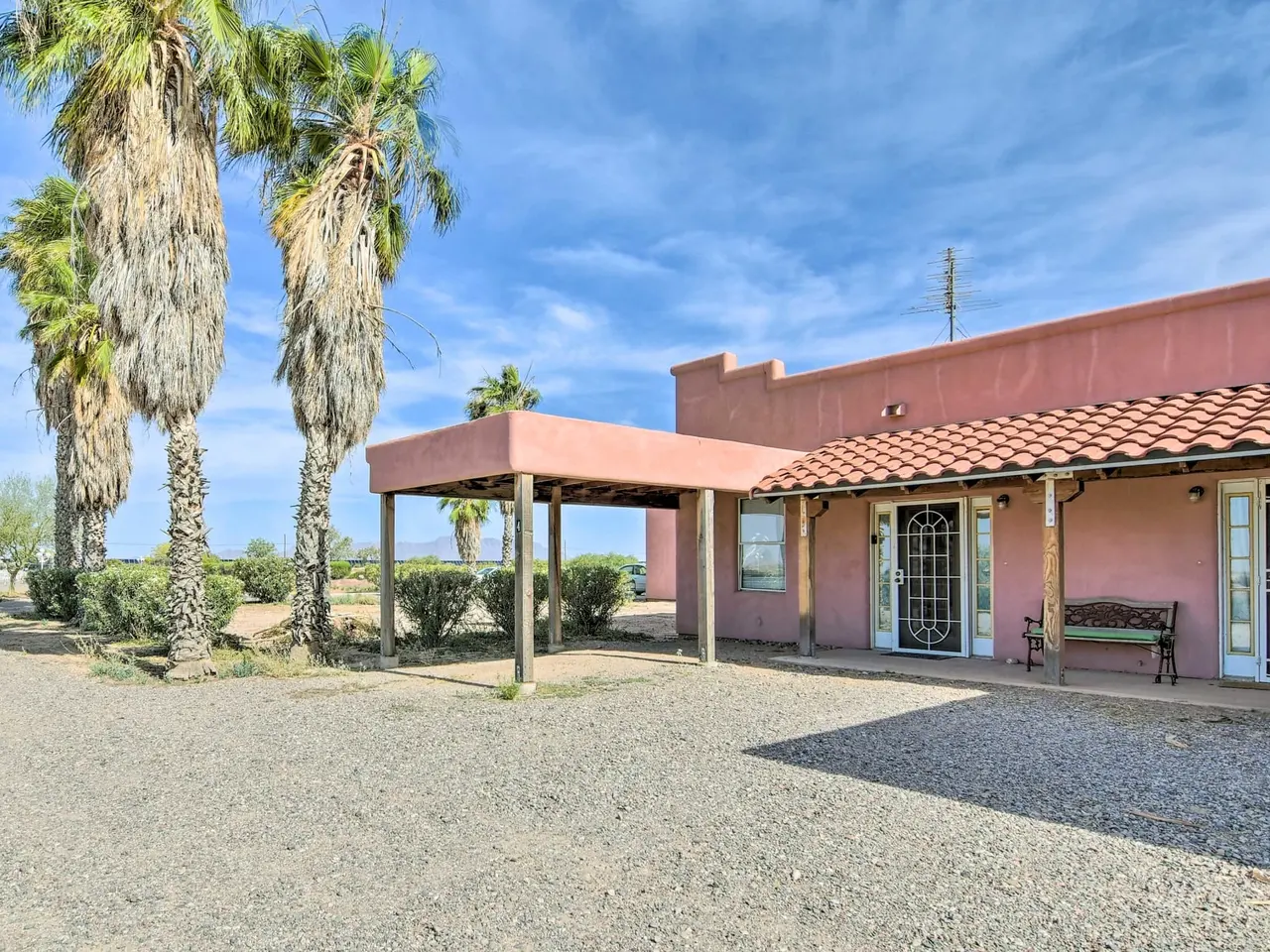 Casa 4: rose adobe exterior with covered parking and palms