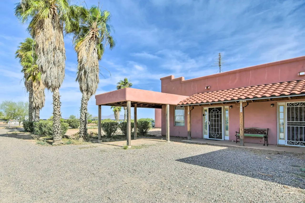 Casa 4: rose adobe exterior with covered parking and palms