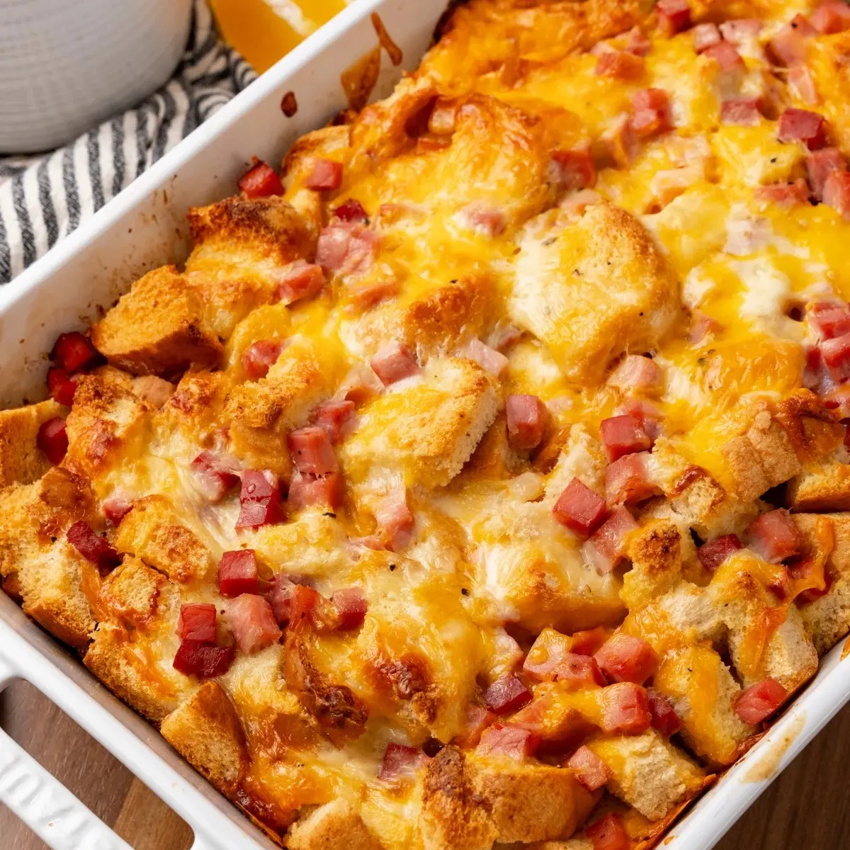 A baked ham and cheese strata in a white dish