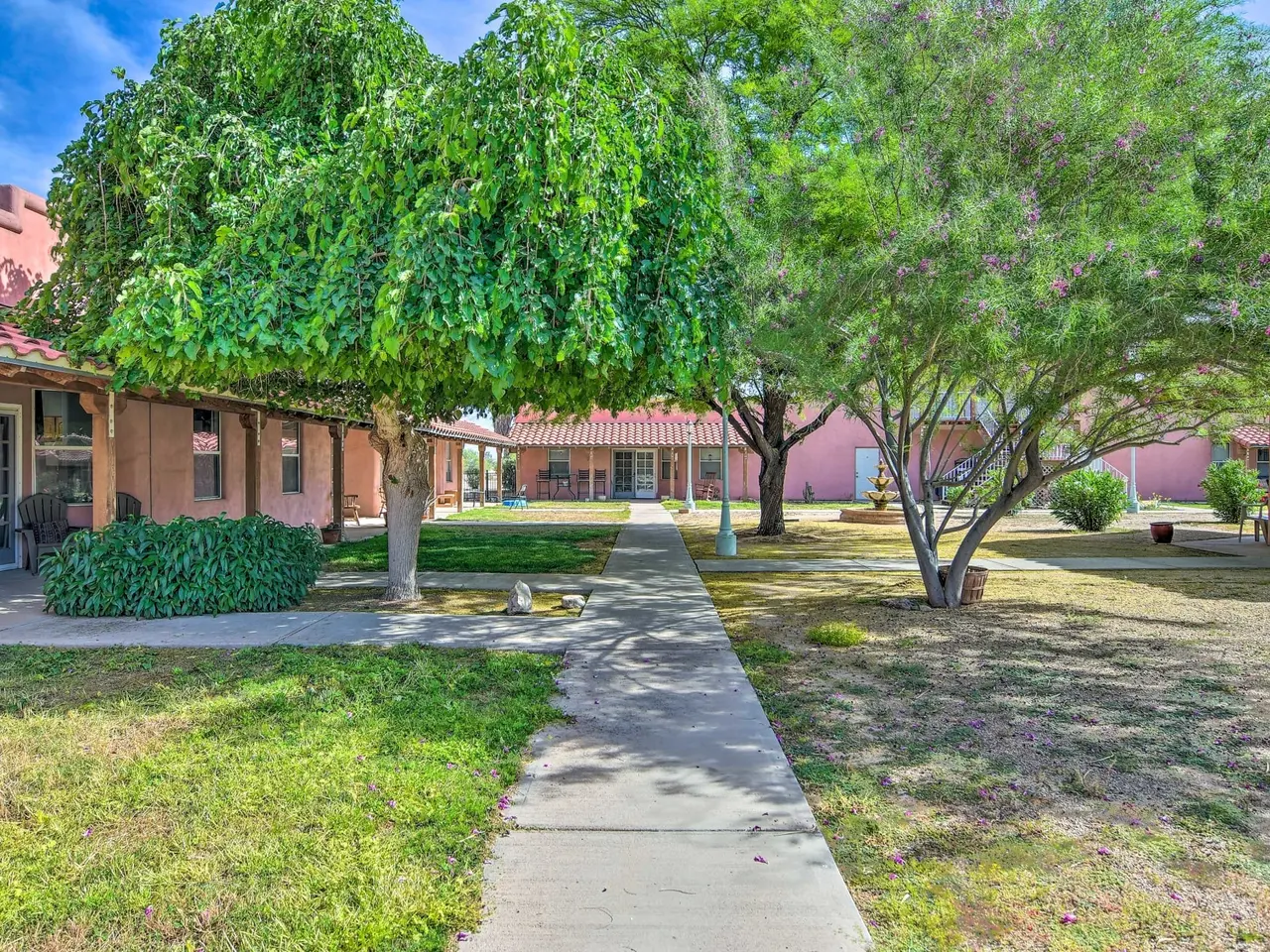 A path through the green casa courtyard under weeping trees