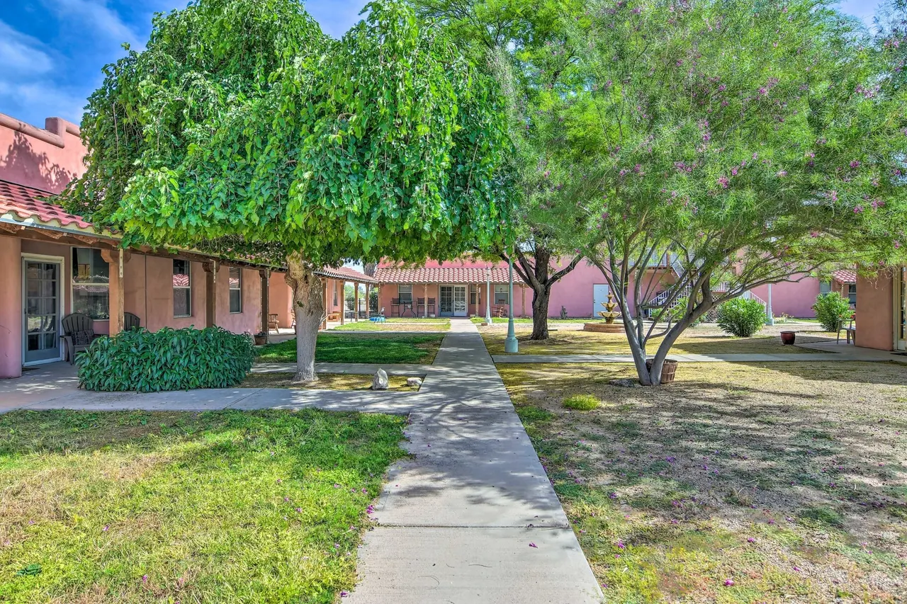 A path through the green casa courtyard under weeping trees