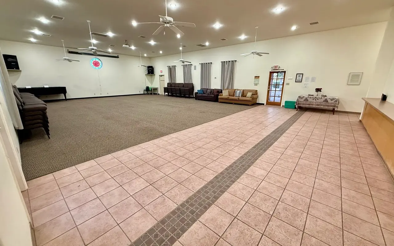 The open meeting hall: carpeted floor, tiled aisle, and a ring of seating