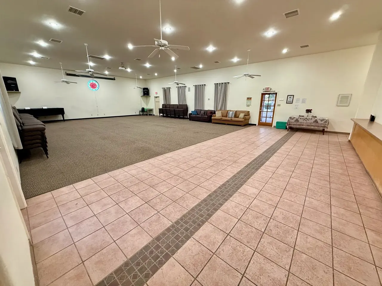 The open meeting hall: carpeted floor, tiled aisle, and a ring of seating