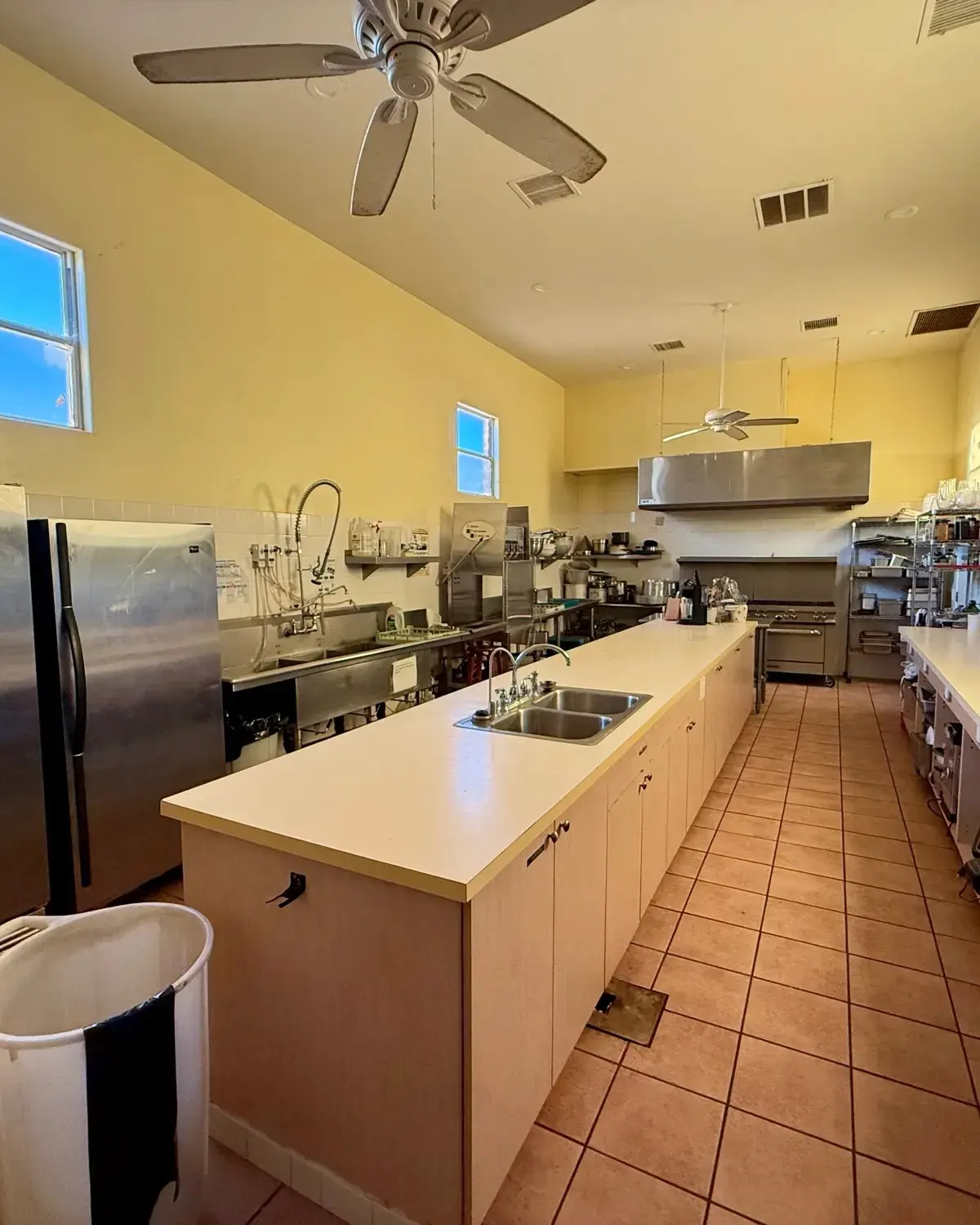 Commercial kitchen with double-door refrigerators, prep sinks and counters