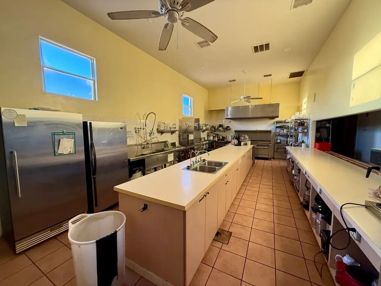 Commercial kitchen with double-door refrigerators, prep sinks and counters