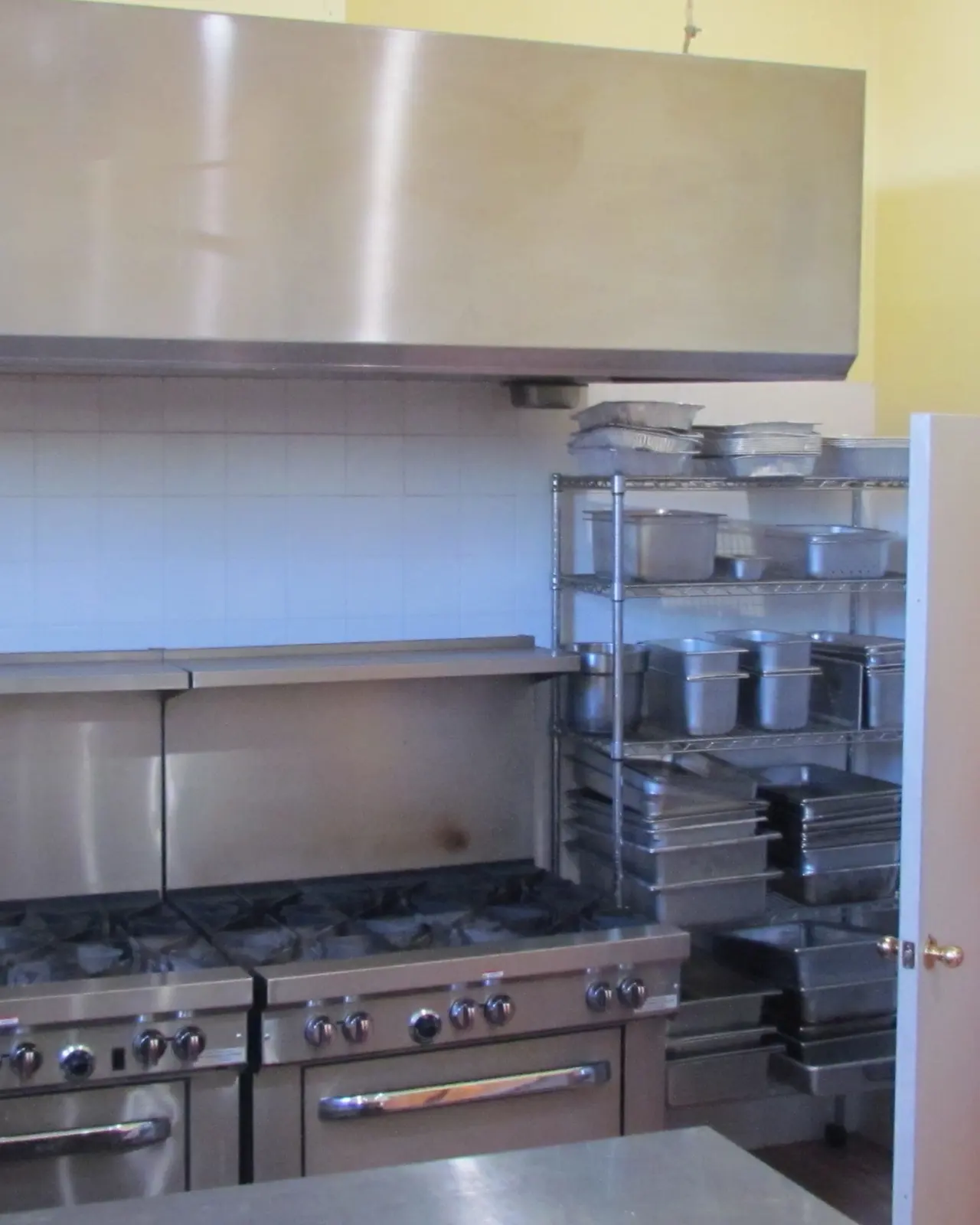 Twelve-burner range and stainless hood in the commercial kitchen