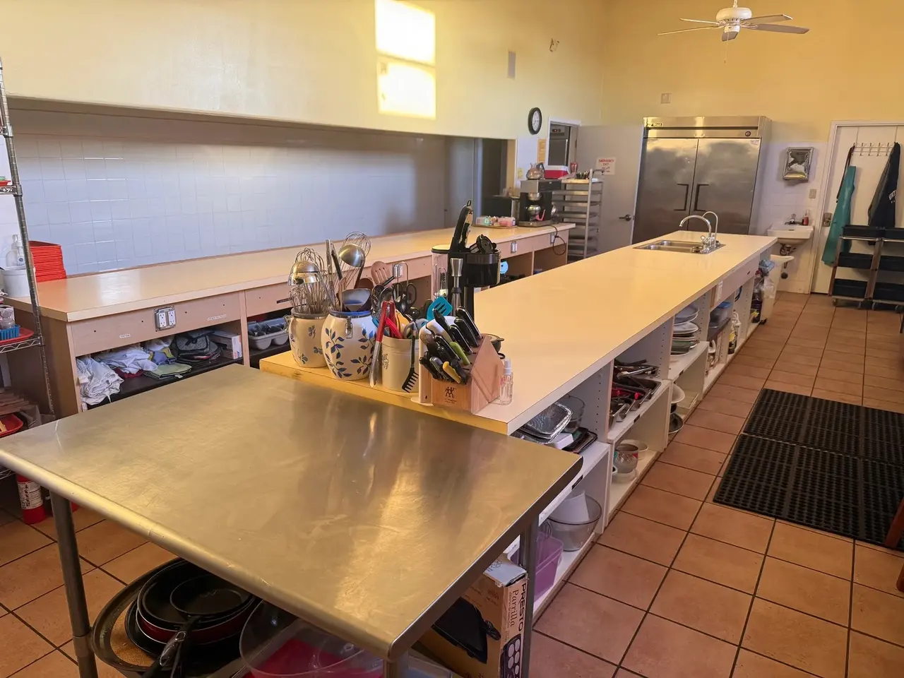 Commercial kitchen with a long stainless prep table and walk-in refrigeration