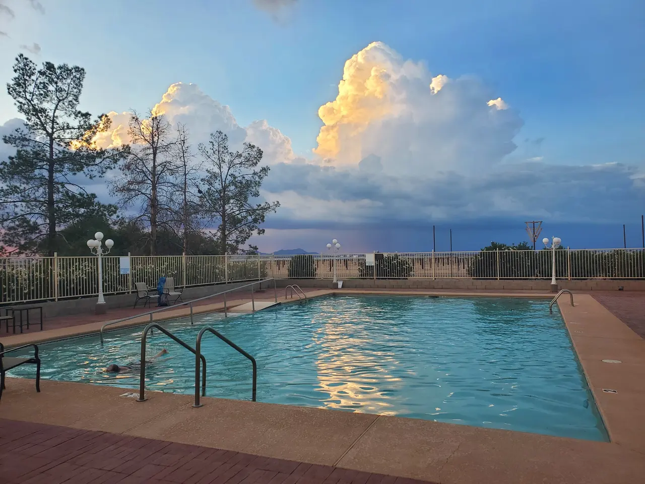 Pool under a towering monsoon cloud in evening light