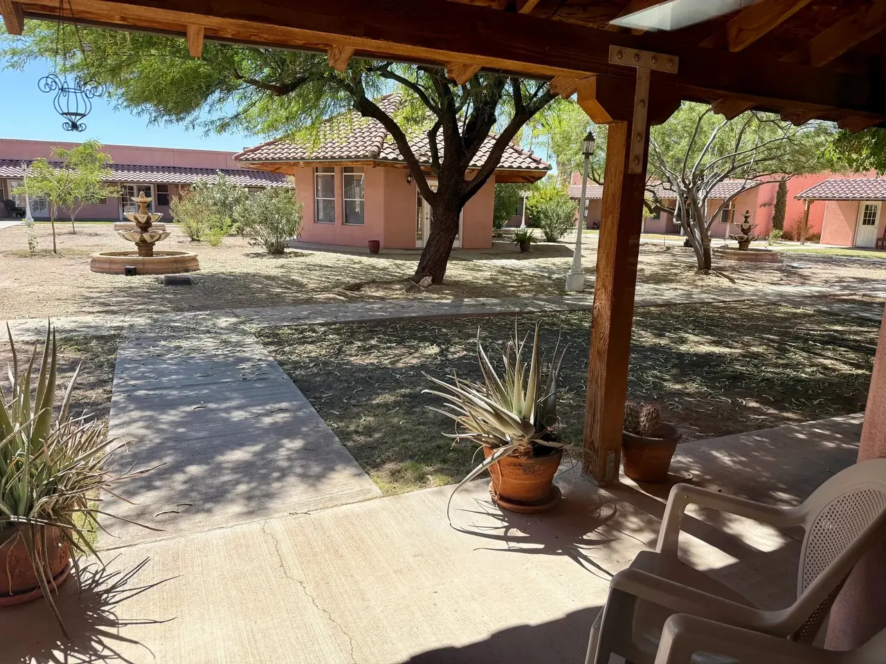 View from a shaded porch across the courtyard and fountain