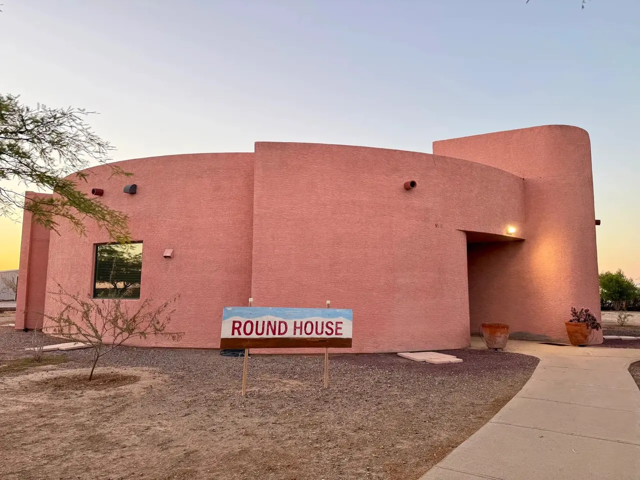The curved adobe Round House at dusk
